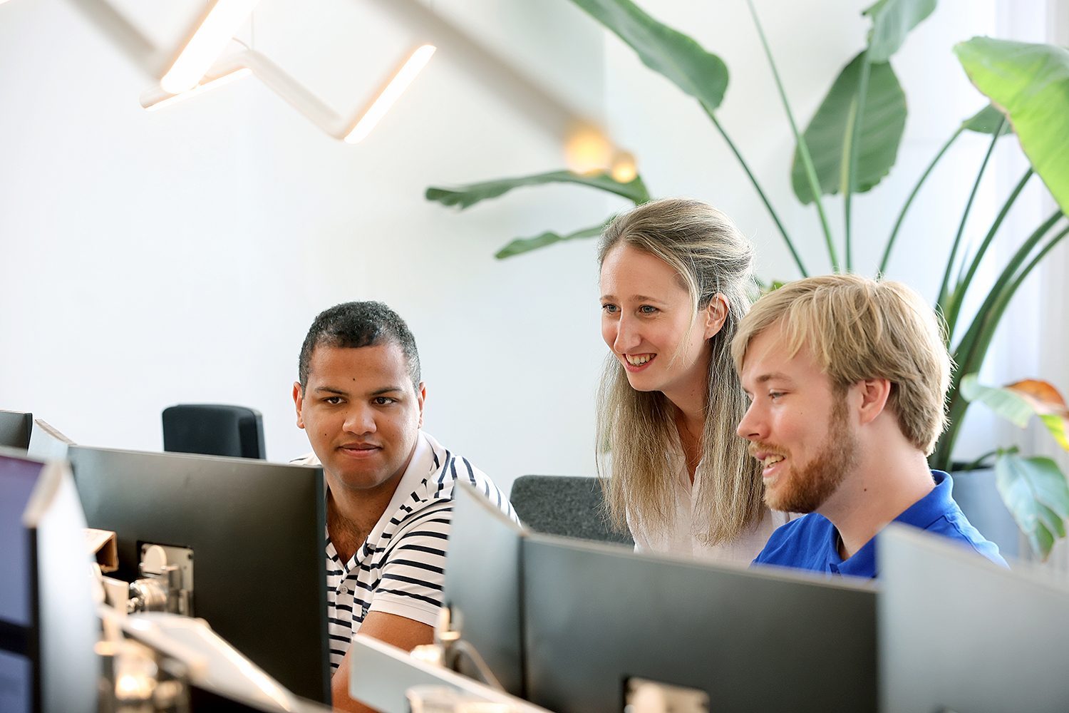 Three colleagues looking at a screen together